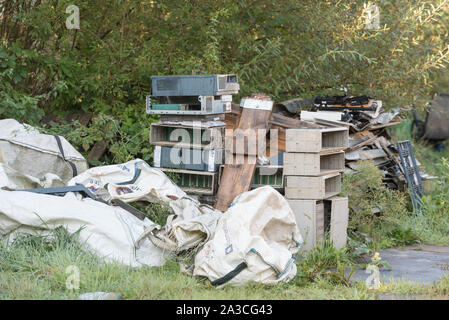 Spazzatura ribaltato sul lato della strada in campagna Foto Stock