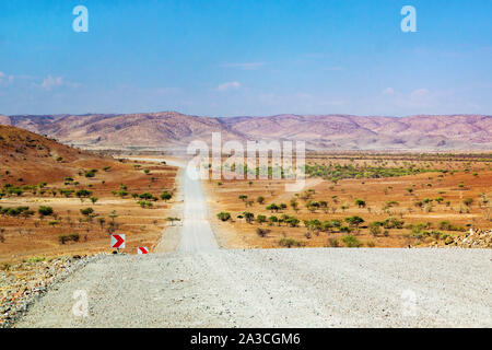 Lunga strada sterrata che conduce attraverso il bellissimo paesaggio del Kaokoland, Namibia, Africa Foto Stock