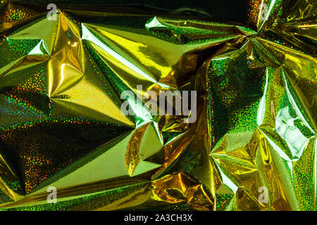 Creative dello sfondo della foto di oro accartocciata olografico lamina verde con punti di luce e ombre Foto Stock