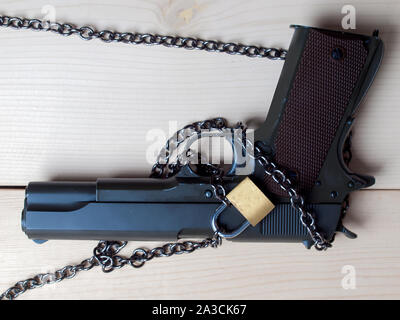 Pistola , armi per la protezione , Pistola dietro il blocco e la catena. Foto Stock