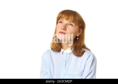 Colpo di Testa di redheaded ragazza con le lentiggini e bang acconciatura vestito in maglietta blu e guardando verso l'alto come se sognare qualcosa di piacevole Foto Stock