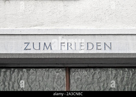 Zum Frieden scritto in lingua tedesca su un muro di casa e di traduzione per la pace Foto Stock