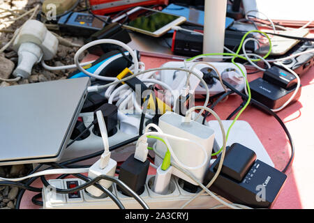 Un mazzetto di gadget di carica, dispositivi elettronici, fili disordinati. dipendenza da energia elettrica. Bashkortostan, Russia, 06.07.2019 Foto Stock