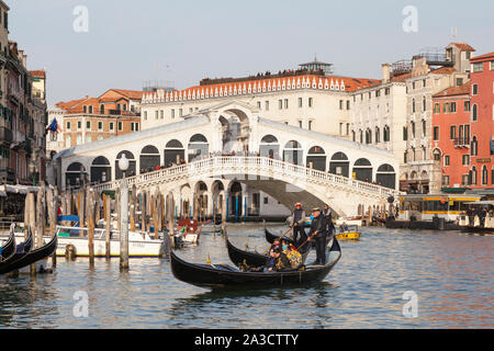 Venezia, Veneto, Italia, gondole con turisti sul Canal Grande sotto il ponte di Rialto in luce della sera Foto Stock