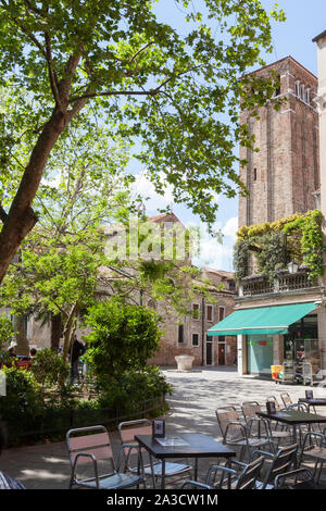 Campo San Giacomo dell Orio, Santa Croce, Venezia, Veneto, Italia in primavera con una vista da un ristorante all'aperto per il campanile della chiesa Foto Stock