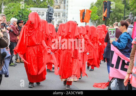 Londra, Regno Unito. 07 ott 2019. Le Brigate Rosse nel loro sangue rosso abiti ancora una volta fare un aspetto. Gli attivisti del clima dall'estinzione della ribellione hanno inscenato una serie di manifestazioni di protesta in vari siti in Westminster, compresi i ponti e diversi ministeri del governo, per accrescere la consapevolezza sul clima globale questioni di emergenza. Credito: Imageplotter/Alamy Live News Foto Stock