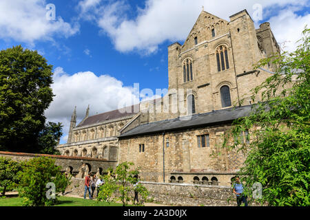 La Cattedrale di Winchester, esterno vista laterale della torre centrale, transetto nord e navata da giardini con cielo blu, Winchester, Hampshire, Regno Unito Foto Stock