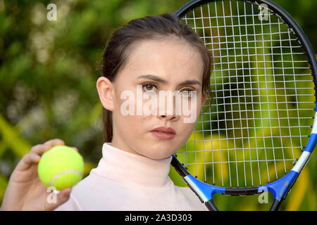 Impassibile ragazza giocatore di tennis con la racchetta da tennis Foto Stock