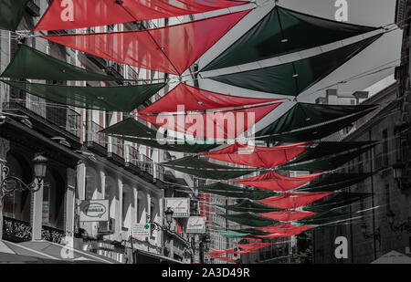 Una foto evidenziando il colorato coperture solari che decorano una strada in Madrid. Foto Stock