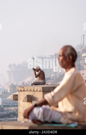 Gli uomini di pregare presso il Gange a Varanasi Foto Stock