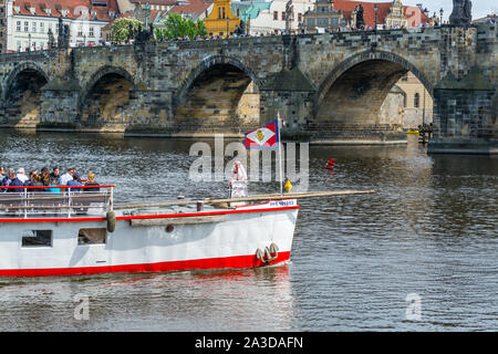 Una nave da crociera passando attraverso il ponte Carlo sul fiume Moldava a Praga, Repubblica Ceca. Foto Stock