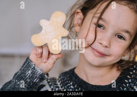 I ragazzi di Natale cottura gingerbread cookie nella cucina della casa sul giorno d'inverno. Close-up bambino le mani preparare i cookie utilizzando cookie cutter. Per la cottura Foto Stock