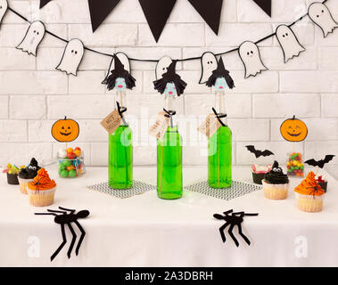 Strega martini cocktail di verde per la festa di Halloween e gustosi tortini Foto Stock