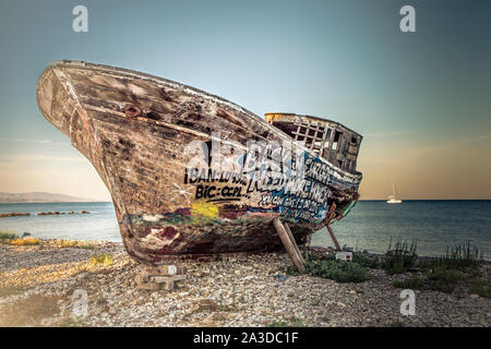 Un vecchio legno barca da pesca coperto di graffiti sul bacino di carenaggio. Foto Stock