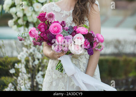 Sposa con un bellissimo mazzo di nozze. Rosa rosa e altri fiori. Foto Stock