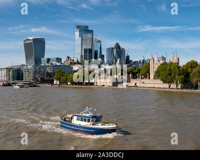 Piccola barca sul fiume Tamigi con la City di Londra grattacieli dietro, London, Regno Unito Foto Stock