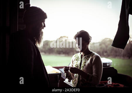 Silhouette di donna e uomo di fronte a un capannone home finestra in fattoria Foto Stock