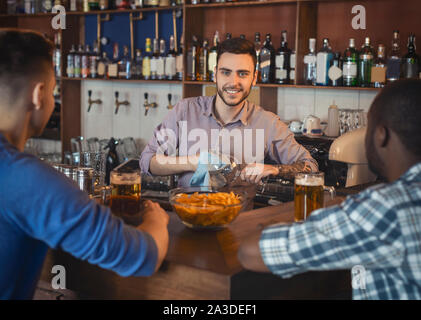 Barista maschio asciugando bicchieri di vino Foto stock - Alamy