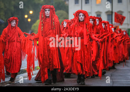 Londra, UK, 07 ott 2019. A seguito del confronto con la polizia, il gruppo tranquillamente a piedi fuori oltre le case del Parlamento. Estinzione della ribellione attivisti del gruppo "Brigate Rosse', con oltre un centinaio di partecipanti, confrontarsi con una linea di polizia a Millbank in Westminster, a muovere lentamente lungo la loro linea e guardando direttamente a funzionari, uno per uno. Credito: Imageplotter/Alamy Live News Foto Stock