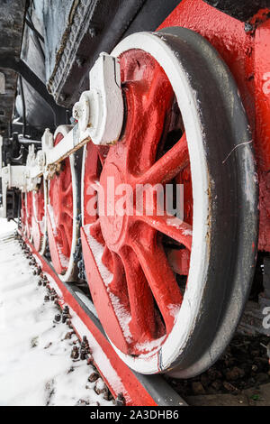 Il sistema di trasmissione trazione locomotiva sulla enorme rosso ruote in metallo Foto Stock