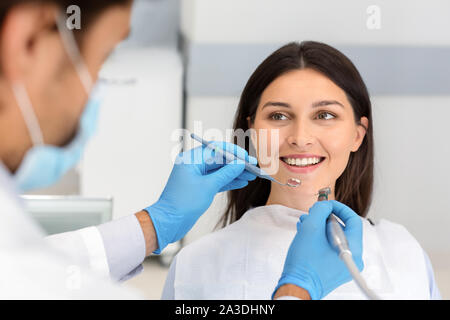 Donna sorridente guardando al dentista con fiducia Foto Stock