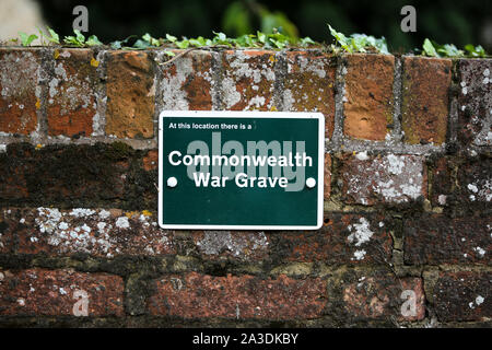 Commonwealth War grave segno su un muro di mattoni di una chiesa nel Regno Unito Foto Stock
