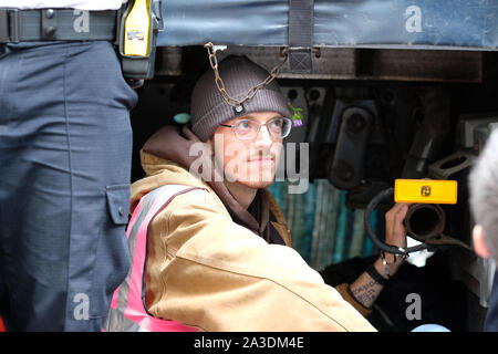 Westminster, London, Regno Unito - Lunedì 7 Ottobre 2019 - molti ribellione di estinzione XR clima manifestanti bloccato se stessi al di sotto di un autocarro in Marsham Street appena al di fuori della Home Office - polizia hanno circondato il veicolo. Foto Steven Maggio / Alamy Live News Foto Stock