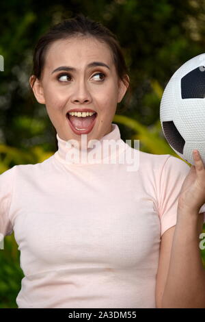Filipina fitness girl giocatore di calcio e la felicità con sfera Foto Stock