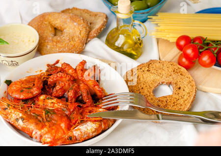 Una gustosa cena per gli amanti di pesce. I gamberetti e i moscardini in salsa di pomodoro. Il cibo italiano concetto. Foto Stock