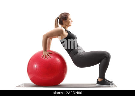 Giovane donna esercizio sit ups con una sfera fitness isolati su sfondo bianco Foto Stock