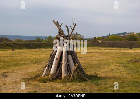 Mucchio di legna da ardere ripiegato sul camino nel campo Foto Stock