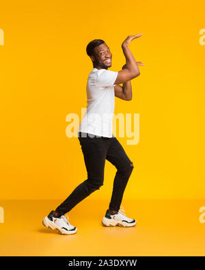 Funny Man Dancing in Egitto Style ingannare su sfondo giallo Foto Stock