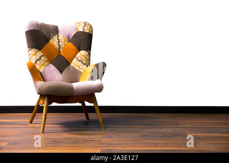 Elegante poltrona moderna con gambe di legno contro un muro bianco all'interno. Arredamento interno, oggetto, designer moderno poltrona. Eleganti interni minimalisti. Copia dello spazio. Sedia Vintage interno Foto Stock