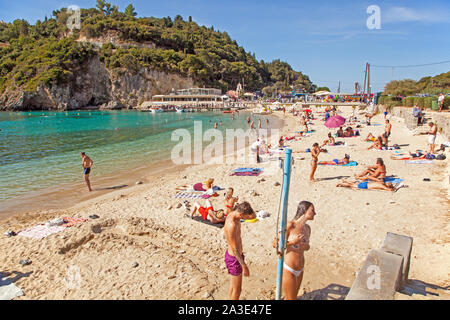 Villeggianti e turisti che si godono il sole sulla spiaggia di sabbia al Greek holiday resort di Paleokastrita sull'isola di Corfu Grecia Foto Stock