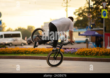 Il ragazzo esegue uno stunt su BMX, in piedi sulla ruota anteriore. Foto Stock