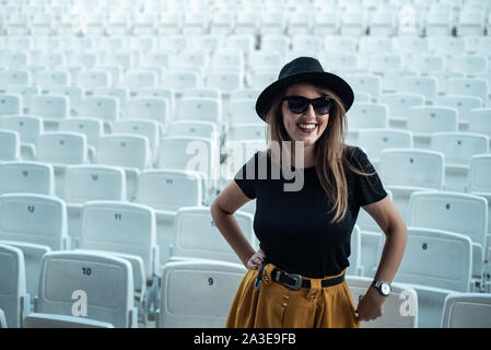 Ragazza alla moda in un teatro vuoto con sedili bianchi Foto Stock