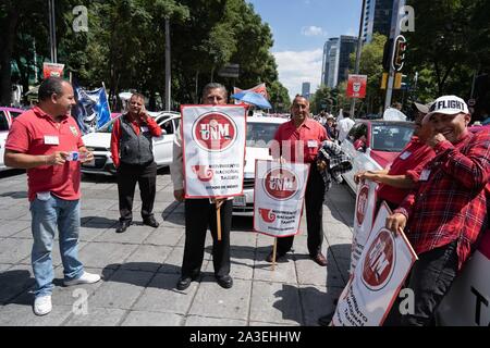 Città del Messico. 07 ott 2019. I conducenti di taxi stand accanto a loro i taxi che erano parcheggiate su una delle strade principali di Città del Messico portando le strade per una sosta durante la protesta.Migliaia di taxi sono visto parcheggiata sulle strade intorno alla statua dell'Angelo di indipendenza di Città del Messico. Slogan sul parabrezza leggere Fuera Aplicacion transnacionales (richiedendo la rimozione di applicazioni straniere). Credito: SOPA Immagini limitata/Alamy Live News Foto Stock