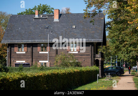 Potsdam, Germania. 07 ott 2019. Un tipico log cabin sorge nell'insediamento Alexandrovka nel nord della capitale dello stato. Il re Federico Guglielmo III di Prussia aveva l'insediamento costruito nel 1826/27 per gli ultimi dodici cantanti russi di un coro precedentemente costituito da 62 soldati. È stato un Sito Patrimonio Mondiale dell'UNESCO in Potsdam dal 1999. Credito: Monika Skolimowska/dpa-Zentralbild/dpa/Alamy Live News Foto Stock