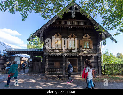 Potsdam, Germania. 07 ott 2019. I turisti passano un tipico log cabin in Alexandrovka insediamento a nord della capitale dello stato. Il re Federico Guglielmo III di Prussia aveva l'insediamento costruito nel 1826/27 per gli ultimi dodici cantanti russi di un coro precedentemente costituito da 62 soldati. È stato un Sito Patrimonio Mondiale dell'UNESCO in Potsdam dal 1999. Credito: Monika Skolimowska/dpa-Zentralbild/dpa/Alamy Live News Foto Stock