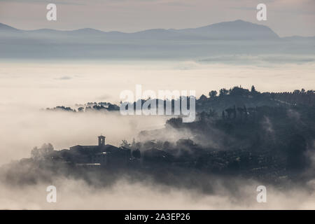 Surreale in vista di una piccola città in Umbria (Italia) quasi completamente nascosto dalla nebbia Foto Stock
