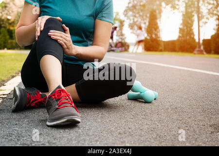 Donna fitness runner sentire dolore al ginocchio. Outdoor esercitare attività di concetto Foto Stock