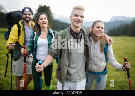 Giovani amici su un paese a piedi. Gruppo di persone passeggiate attraverso la campagna Foto Stock