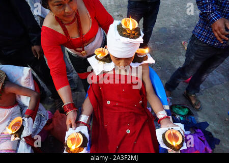 Bhaktapur, Nepal. 8 Ott, 2018. Una donna Nepalese luci lampade a olio sul corpo di un devoto indù durante il festival.Dashain è celebrata per contrassegnare la vittoria secondo religiosi indù scritti di Ramayan oltre il malvagio re demone Ravana e oltre il demone Mahisasur che crudelmente terrorizzato il popolo dell India in forma di raging bufalo d'acqua. Credito: Sunil Pradhan SOPA/images/ZUMA filo/Alamy Live News Foto Stock