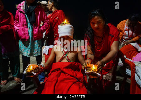 Bhaktapur, Nepal. 8 Ott, 2018. Una donna Nepalese luci lampade a olio sul corpo di un devoto indù durante il festival.Dashain è celebrata per contrassegnare la vittoria secondo religiosi indù scritti di Ramayan oltre il malvagio re demone Ravana e oltre il demone Mahisasur che crudelmente terrorizzato il popolo dell India in forma di raging bufalo d'acqua. Credito: Sunil Pradhan SOPA/images/ZUMA filo/Alamy Live News Foto Stock