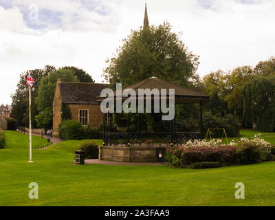 Bandstand Cutts nel vicino parco Oakham Capoluogo di contea di Rutland East Midlands England Regno Unito vista del campanile della chiesa di Tutti i Santi Foto Stock