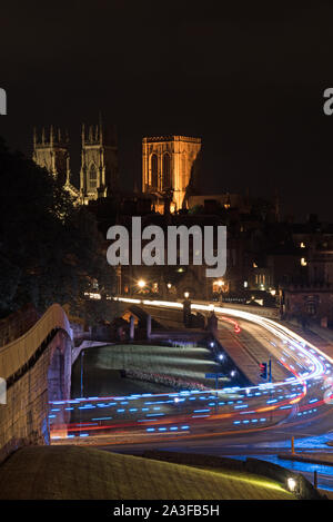 Notte Tempo immagine guardando attraverso Lendal ponte di fronte ovest e la torre centrale di York Minster da York le mura della città con percorsi di luce in primo piano Foto Stock