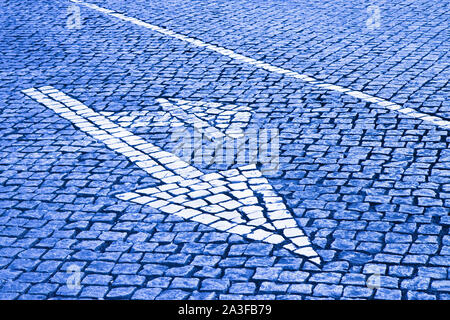 Freccia bianca sulla strada di pietra - Concetto di immagine - immagine dai toni Foto Stock