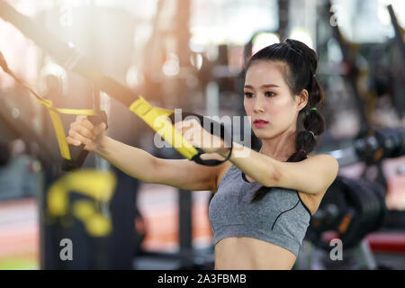 Donna Fitness esercizio con esercizio-macchina Crossover cavo in palestra Foto Stock