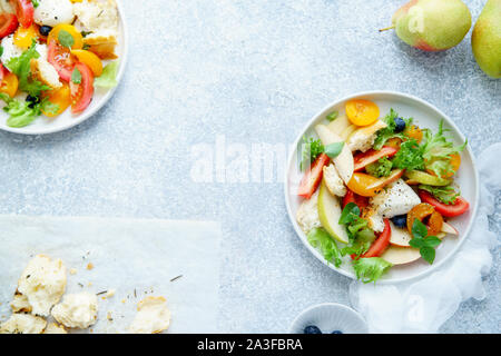 La panzanella originale insalata con mozzarella, tostate baguette, pomodori e prugne su sfondo rustico. Cucina estiva concept Foto Stock