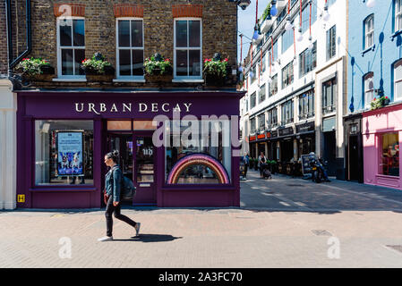 London, Regno Unito - 15 Maggio 2019: il degrado urbano cosmetici storefront ferma in Carnaby Street a Londra. La donna non identificato in primo piano Foto Stock